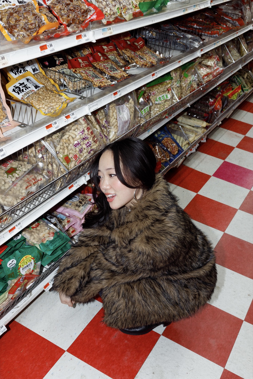 Sitting on a checkered floor among shelves
