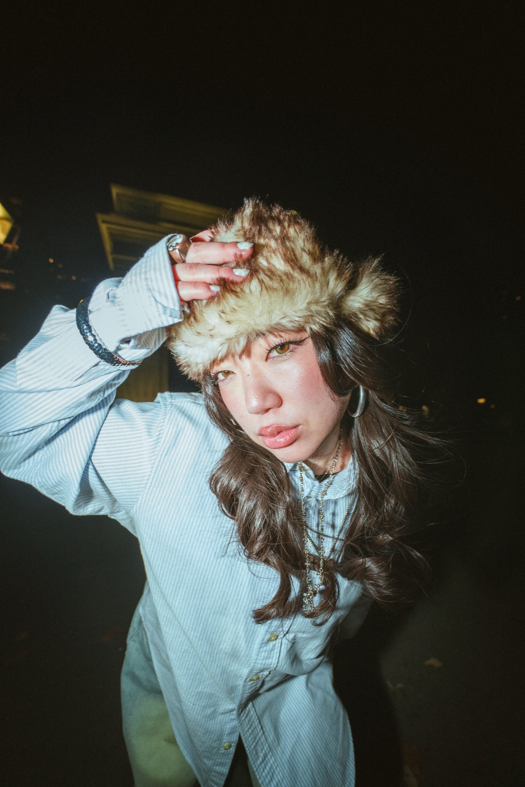 Night flash portrait in a fur hat