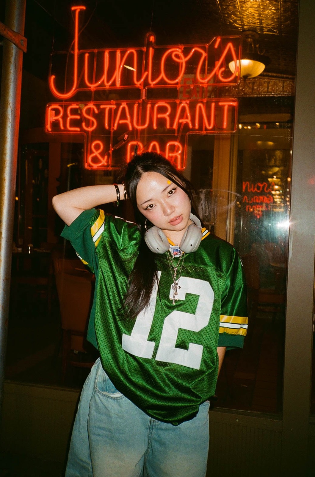 Yoonji under a neon restaurant sign